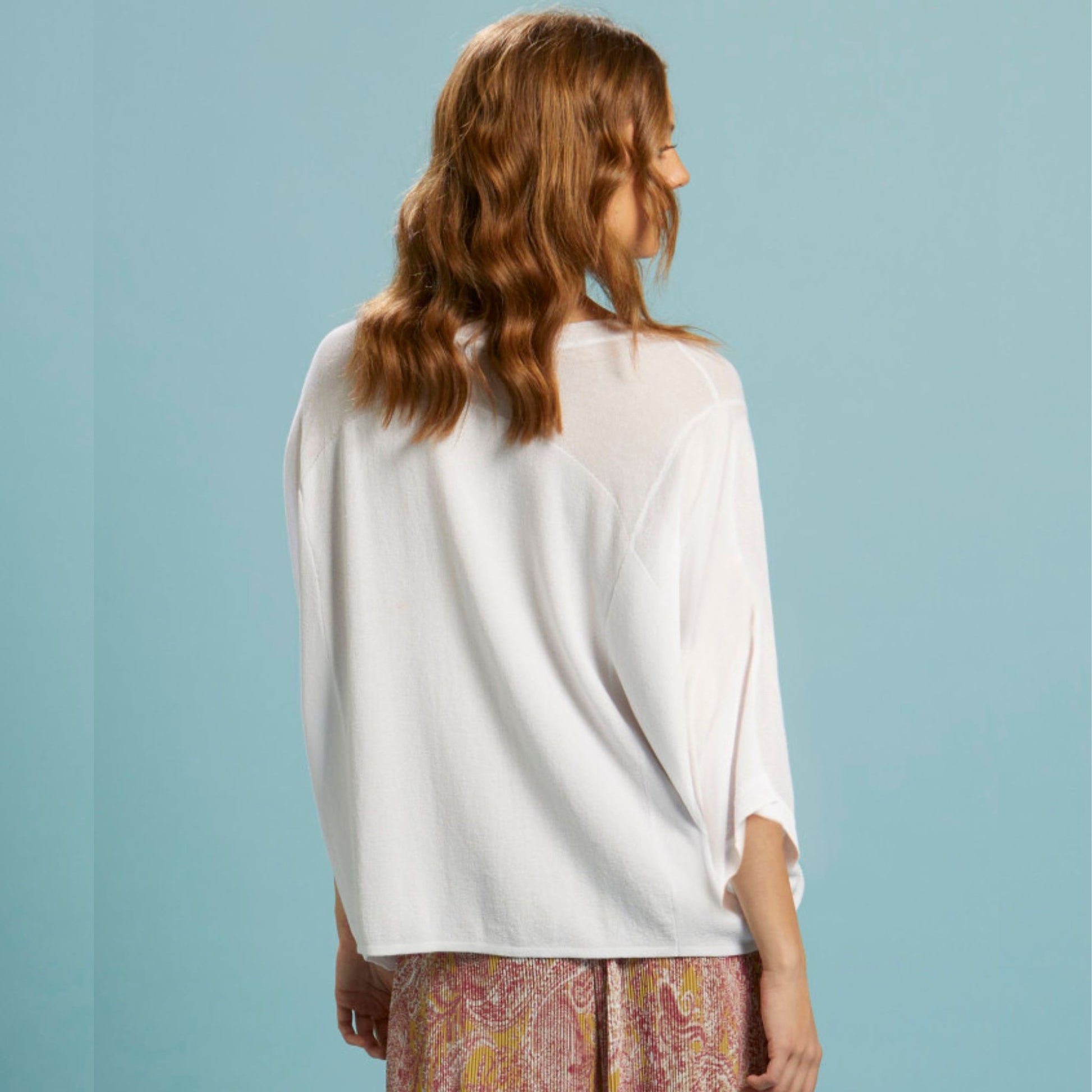The boat neck shape on the Celestial knit from FATE + BECKER adds a touch of sophistication to any outfit. With a hi/lo hem and side splits, this lightweight knit in white achieves a modern and stylish look.