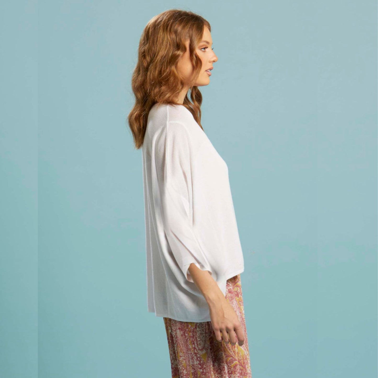 The boat neck shape on the Celestial knit from FATE + BECKER adds a touch of sophistication to any outfit. With a hi/lo hem and side splits, this lightweight knit in white achieves a modern and stylish look.