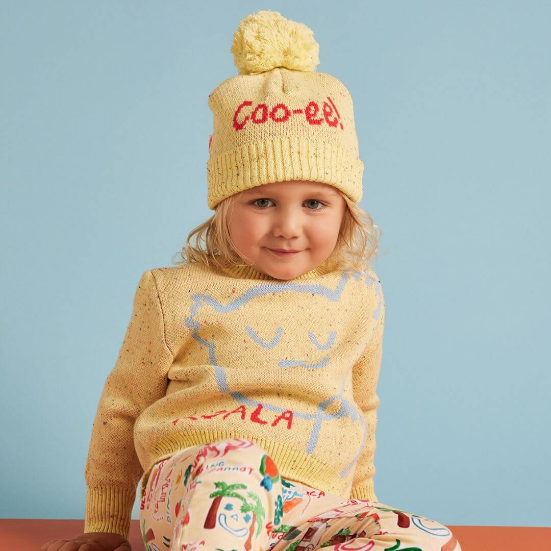 Halcyon Nights Sunny koala knit beanie is a super cute yellow machine washable beanie featuring a super cute pale blue koala print and coo-ee! on the back.