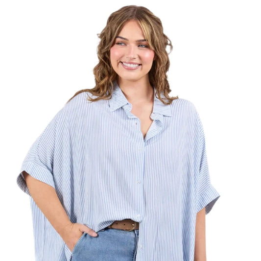 Woman wearing a light blue striped shirt and jeans on a white background