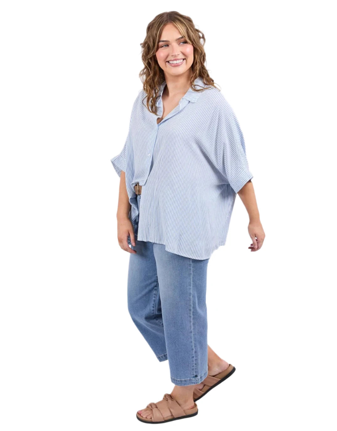 Woman wearing a light blue checkered shirt and jeans on a white background