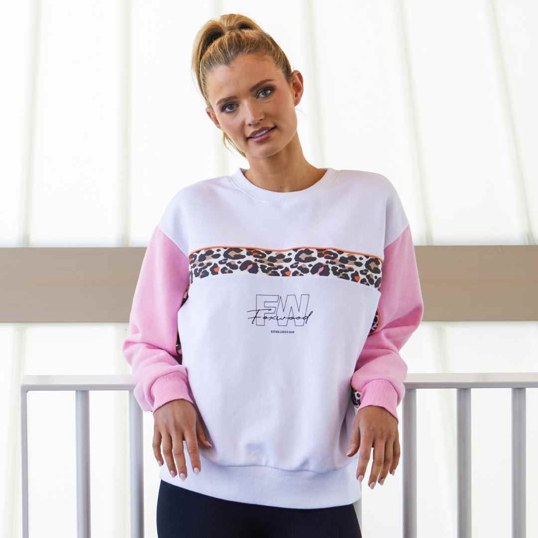 The Leopard crew from the Foxwood Leisure collection is a white crew with pink sleeves featuring a pop of leopard print across the chest and inside of the sleeves