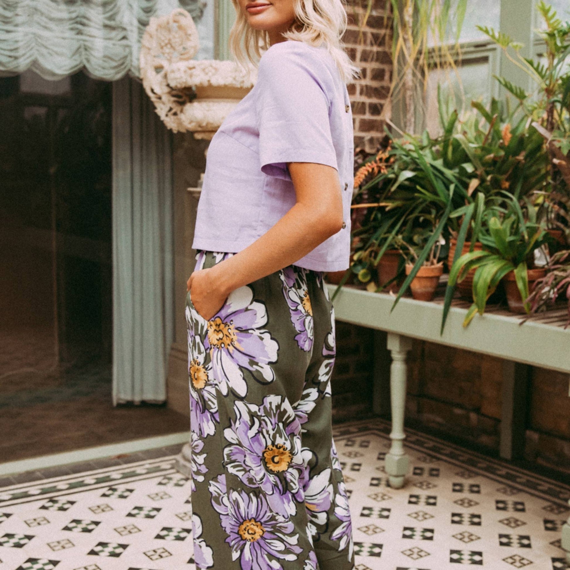 Made from flattering and drapey linen lyocell the Antheia Floral Wide Leg Pant from Elm pants are the ideal seasonal addition to your wardrobe. These wide leg pants have a green base with lilac petaled watercolour flowers. The pants have pockets and a drawstring paperbag waist
