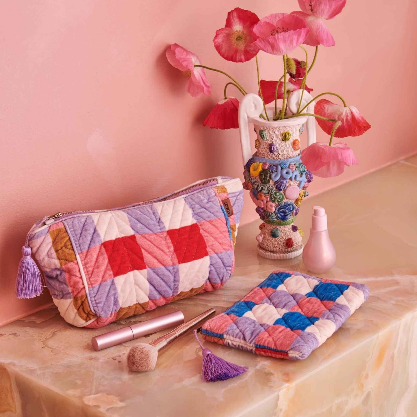 The Summer Check Velvet Toiletry Bag features printed quilted velvet with a check pattern of pink, purple, blue, red, mustard brown and white with feature purple zip tassel.